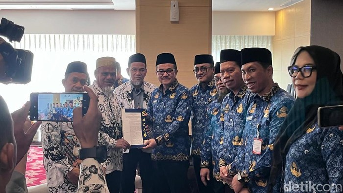 1763358801590-sekda-sulsel-dr-jufri-rahman-menyerahkan-sk-pengaktifan-kembali-menjadi-asn-kepada-dua-guru-sma-di-luwu-utara-1763344493029_169