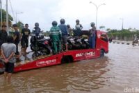 1763809560718-warga-membuka-jasa-mengangkut-motor-untuk-menyeberangi-banjir-di-jalan-perintis-kemerdekaan-makassar-mengunakan-mobil-towing_169