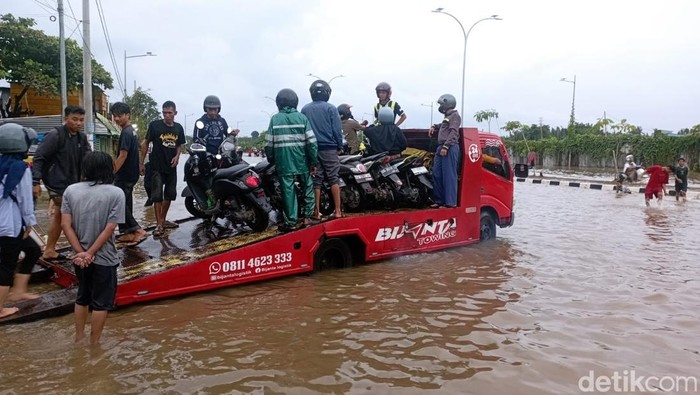 1763809560718-warga-membuka-jasa-mengangkut-motor-untuk-menyeberangi-banjir-di-jalan-perintis-kemerdekaan-makassar-mengunakan-mobil-towing_169